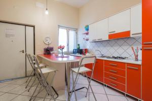 a kitchen with orange cabinets and a counter with chairs at B&B President in Sant'Egidio del Monte Albino