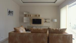 a living room with a couch and a tv at Dipan Guest House Yogyakarta in Yogyakarta