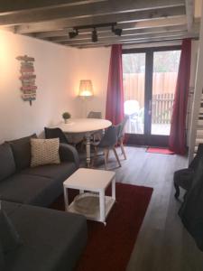 sala de estar con sofá y mesa en Maison à l'Amélie Plage, 300 mètres de la plage/mer, en Soulac-sur-Mer