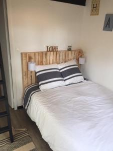 Un dormitorio con una cama con un signo de amor. en Maison à l'Amélie Plage, 300 mètres de la plage/mer, en Soulac-sur-Mer