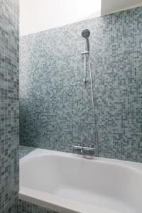 a shower in a bathroom with a bath tub at Veeve - Eiffel Elegance in Paris