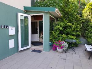 eine offene Tür eines Hauses mit Blumen und einer Bank in der Unterkunft Mini dvivietis in Vilnius