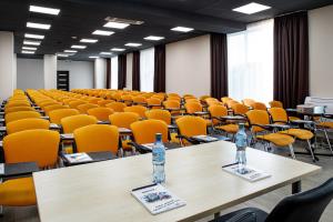 Barkhatnye Sezony Yekaterininsky Kvartal Resort في أدلر: غرفة محاضرات فارغة مع طاولات وكراسي