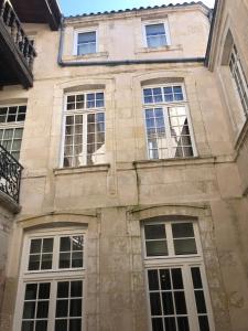 un bâtiment avec plusieurs fenêtres sur son côté dans l'établissement Very quiet 2-room apartment - Old Port, Town center, à La Rochelle