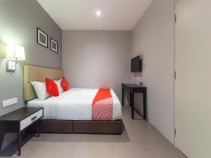 a bedroom with a bed and a desk and a television at Super OYO 1191 Yootel Boutique Hotel in Kajang