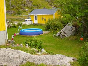 a yellow house with a swimming pool in a yard at Edvinstua in Pettvik