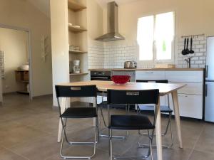 a kitchen with a wooden table and black chairs at Chez Georges - Maison 2 - Les Gîtes du Verdon in Esparron-de-Verdon