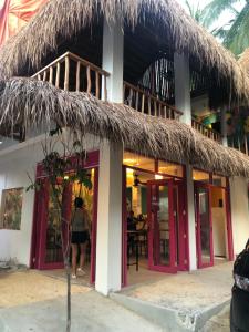 a restaurant on the beach with a thatched roof at Way Shack Hostel in Oslob