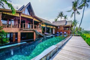 una casa con piscina al lado de una casa en Villa Tao, en Tabanan