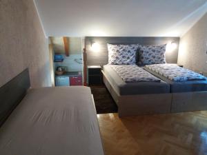 a small bedroom with two beds and a table at Smx Apartement in Prelog
