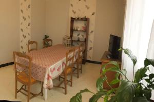 - une salle à manger avec une table, des chaises et une télévision dans l'établissement le Jardin d'Odette, à Yèvres-le-Petit