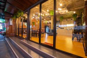 a restaurant with a wooden floor in a room with windows at Kaen Hostel in Pattaya Central