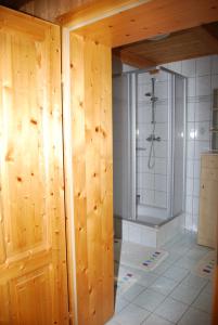 a bathroom with a shower and a wooden door at Bauernhof Hatzlhof in Schöder