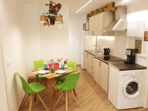 małą kuchnię ze stołem i zielonymi krzesłami w obiekcie Wonder Nerja Paraiso Apartamento w mieście Nerja