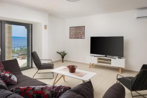 Televízia a/alebo spoločenská miestnosť v ubytovaní Absolute Beach Villa
