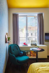 ein Schlafzimmer mit einem blauen Stuhl und einem Fenster in der Unterkunft Max Brown Hotel 7th District, part of Sircle Collection in Wien
