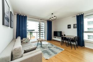 sala de estar con sofá y mesa en PoBookowane Stocznia Apartments Gdańsk en Gdansk