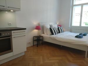 a bedroom with a bed and a kitchen with a window at Prague Saints Apartments in Prague