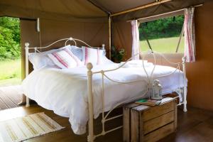 um quarto com uma cama branca numa tenda em Brocklands Farm Glamping em Petersfield