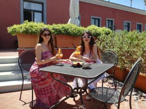 two women sitting at a table with drinks at Hotel Nuvò in Naples