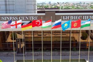 a group of flags in front of a building at Parliament Palace Hotel in Khujand