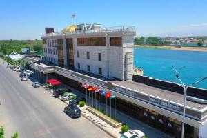 a building with cars parked in front of a street at Parliament Palace Hotel in Khujand