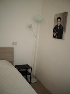um quarto com um candeeiro e uma fotografia na parede em Appartamento in Centro Storico, vicino alla Stazione e al Mare em Rimini