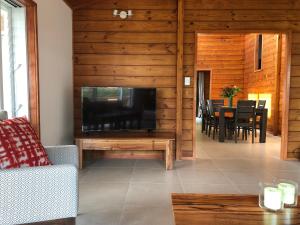 uma sala de estar com uma grande televisão e uma mesa em Pacific views, tranquil location, large home Navy House 2 em Rarotonga