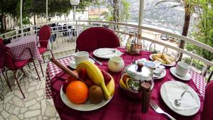 une table avec des fruits sur un tissu de table rose dans l'établissement Hotel Bokeljski Dvori, à Kotor