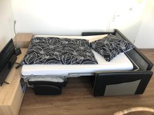 a bed with a black and white comforter on it at Ferienwohnung Janson in Wiesenbach