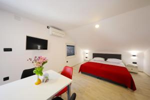 1 dormitorio con cama roja y mesa en Apartman Sofia, en Zadar 37 fotos más