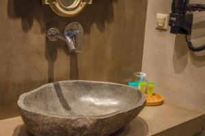 a bathroom sink with a large stone bowl at Agorastos Hotel in Koinyra
