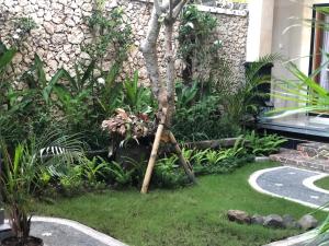 un jardín con una palmera en el césped en Taman Indah Homestay, en Ubud