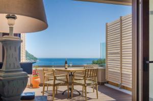 a table and chairs on a balcony with a view of the ocean at Agorastos Hotel in Koinyra