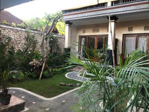 una casa con un jardín delante de ella en Taman Indah Homestay, en Ubud