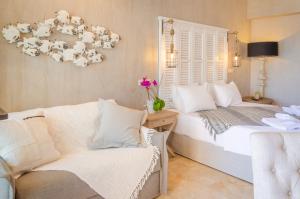 a bedroom with two beds and a couch and a chandelier at Agorastos Hotel in Koinyra