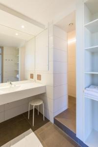 La salle de bains est pourvue d'un grand lavabo et d'un tabouret. dans l'établissement Vakantie Domein Ter Helme, à Oostduinkerke