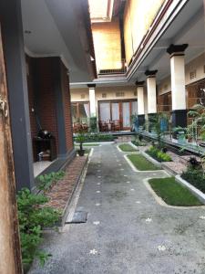 an empty courtyard of a building with plants at Taman Indah Homestay in Ubud