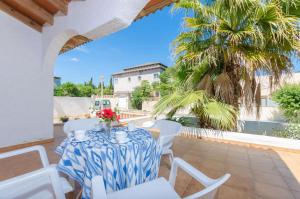 a table and chairs on a patio with a palm tree at Perú in Son Serra de Marina