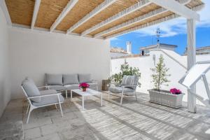patio z krzesłami i stołem na białej ścianie w obiekcie CasaMia w mieście Alliste