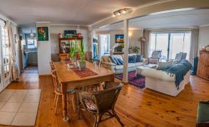 a kitchen and living room with a table and chairs at Sitterus in Stilbaai