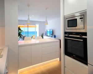 a kitchen with a microwave oven and a counter top at Apartamento frente al mar in Canet de Mar