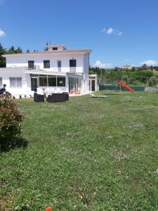 a large white house with a large yard with a house at Osteria dell'Americano in Potenza