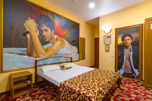 una habitación de hotel con una cama con una pintura en la pared en Apartment & Guest Rooms ART Bukhta, en Sevastopol