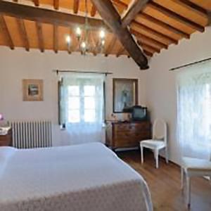 a bedroom with a bed and a table and a chair at AGRITURISMO Casale Il Caggio in Ciggiano