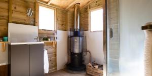 a small kitchen with a heater in a tiny house at Brocklands Farm Glamping in Petersfield