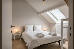 a bedroom with a white bed with two pillows on it at Logement Den Beer in Meerhout