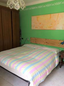 Ce lit se trouve dans une chambre dotée d'un mur vert. dans l'établissement Acero Rosso, à San Colombano