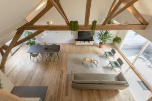 vistas panorámicas a una sala de estar con sofá y mesa en Logement Den Beer en Meerhout