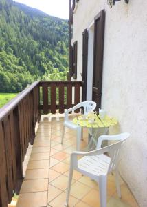 un patio con 2 sillas y una mesa en el balcón en Acero Rosso en San Colombano